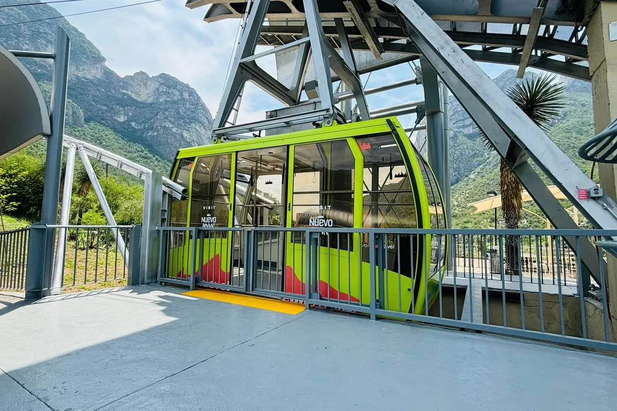 Teleférico de las Grutas de García descendiendo la montaña con la sierra de Nuevo León de fondo